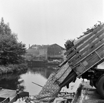 125859 Afbeelding van het storten van huisvuil in vuilnisschuiten in de Biltsche Grift op het Vaaltterrein te Utrecht.
